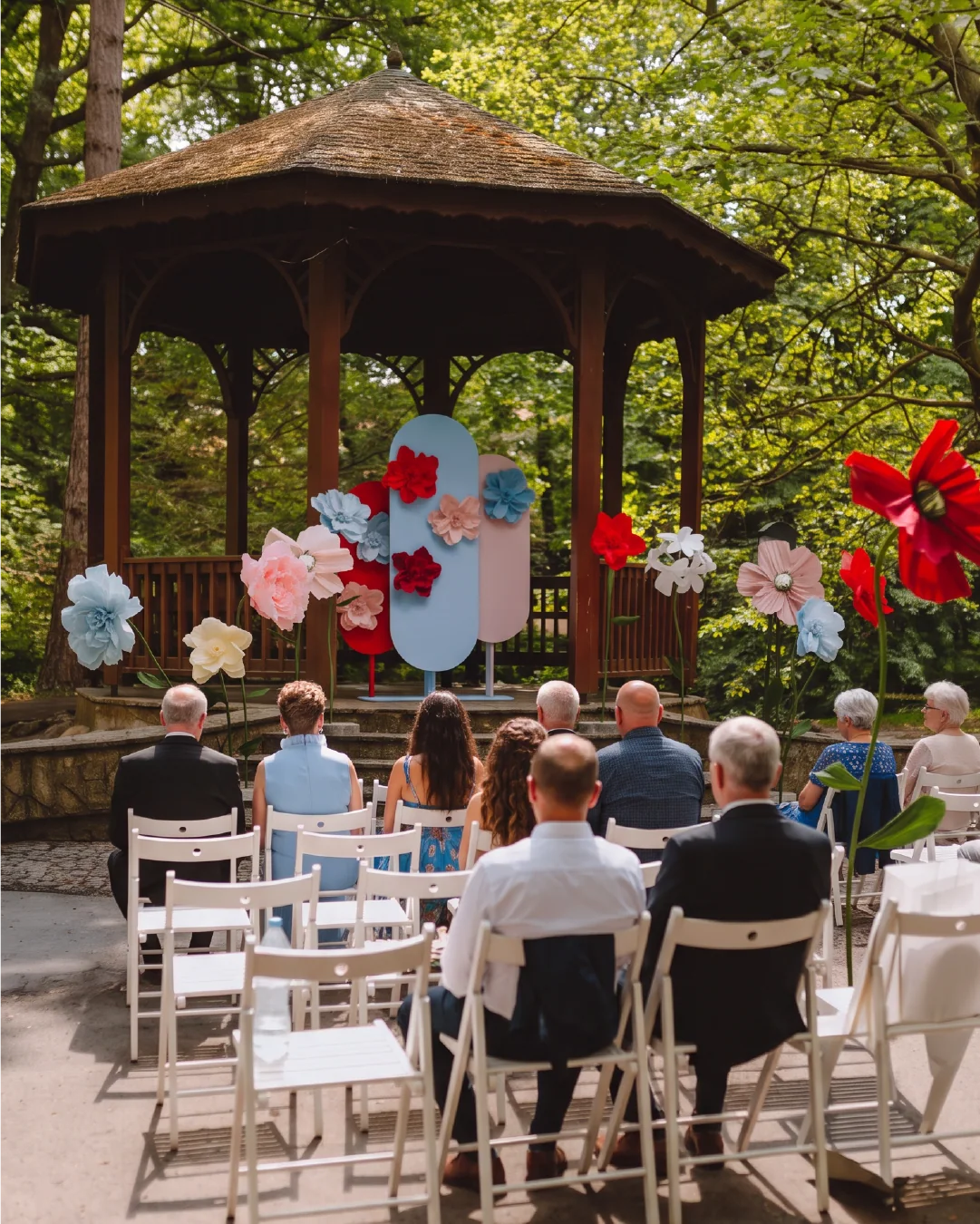 Papierowe kwiaty XXL przy altanie podczas plenerowej ceremonii ślubnej